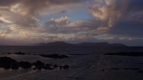 White clouds over silhouette mountains and sea at dusk Stock Footage 105418340