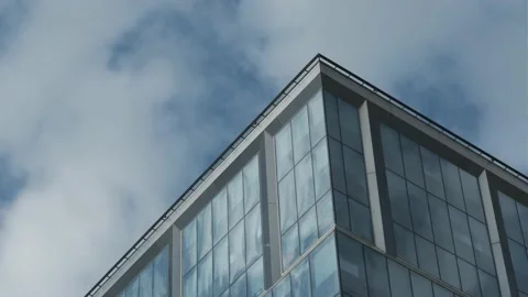 White clouds passing by and reflecting in the windows of the building Stock Footage 140594454