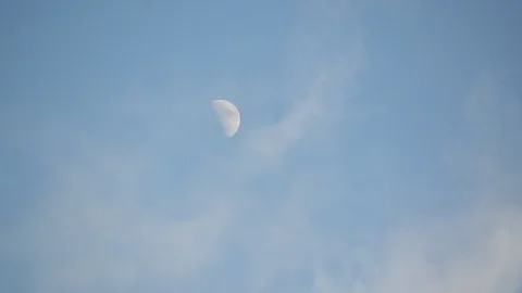 White clouds passing in front of the Moon. Clouds running over blue sky Stock Footage 103186568