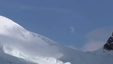 White clouds passing over the moon and snowy mountains Vídeos de archivo 335100550