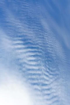 White clouds like a sea wave shape in the light blue sky as background. Stock Photos