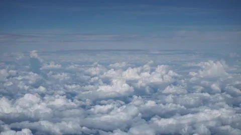 White clouds shot from the window of a airplane in a bright blue sky. Stock Footage 137676712