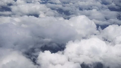 White clouds shot from the window of a airplane in a bright blue sky. Stock Footage 137676729