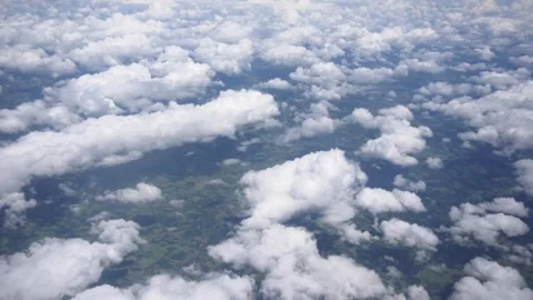 White clouds shot from the window of a airplane in a bright blue sky. Stock Footage 137676733