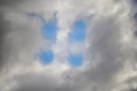 White clouds in the sky and between them you can see the blue sky as if throu Stock Photos