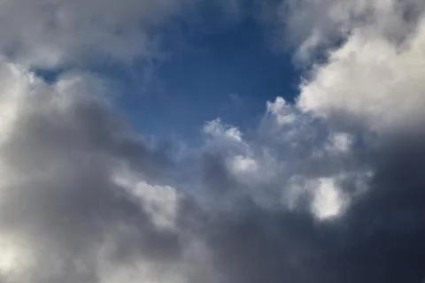 White clouds in the sky and between them you can see the blue sky, clouds hig Stock Photos