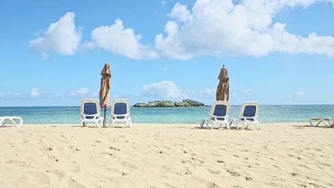 White clouds slowly float above empty seashore with beach chairs and closed Video stock 129772712