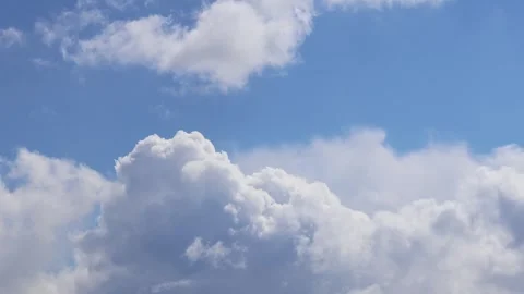White clouds slowly float across the bright blue sky Stock Footage 274652256
