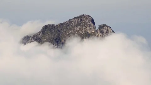 White clouds slowly moves over top mountain. Stock Footage 76636049