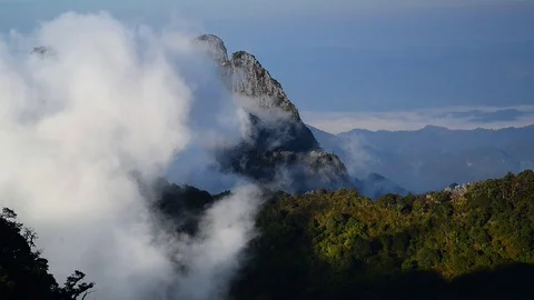 White clouds slowly moves over top mountain. Stock Footage 76637117
