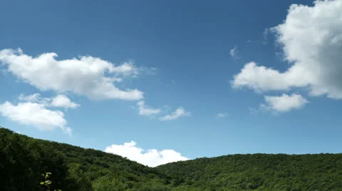 White Clouds timelapse flying over green forest hills Stockbeeldmateriaal 25888769