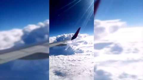 White clouds under the wing of an airplane on a blue sky in the rays of the sun Stock Footage 206418730