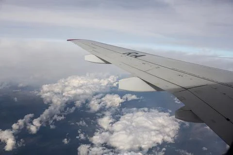 White clouds under the wing of an airplane. Stock Photos