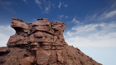 White clouds wrap around the top of the brown rock against the sky. Stock-Footage 146652434
