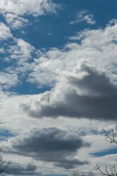 White cloudy clouds against dark blue sky, the sun came out from behind cloud Stock Photos