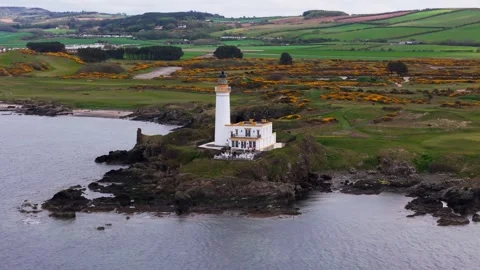 White Coastal Beacon Surrounded by Verdant Hills and private golf course Vídeos de archivo 333955932