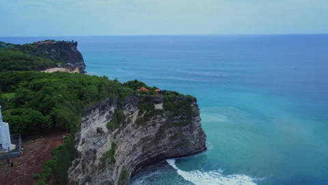 White Coastal Monument Above Cliffs and Turquoise Sea in Bali, Indonesia Видео 345751071