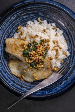 White cod with homemade basil pesto and roasted pine kernels Foto stock