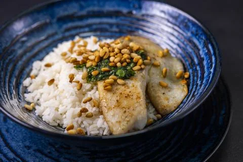 White cod with homemade basil pesto and roasted pine kernels Foto stock