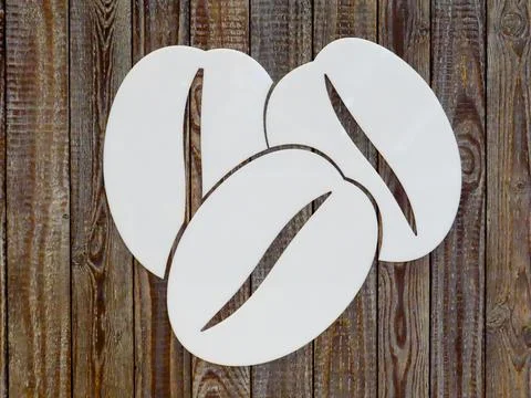 White coffee bean silhouette on rustic wooden background. Stock Photos