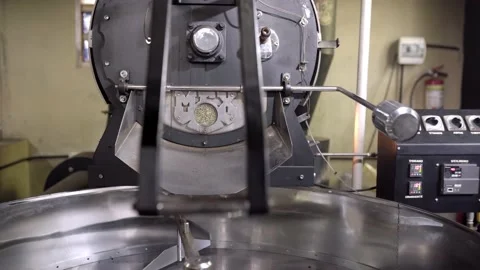 White coffee beans spinning inside of a big coffee roaster machine Stock Footage 219592188
