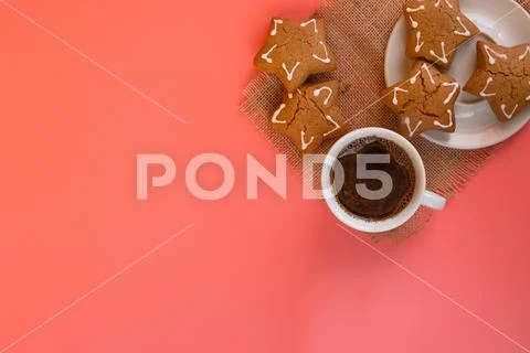 White coffee Cup and saucer on pink background with gingerbread. Stock Photos