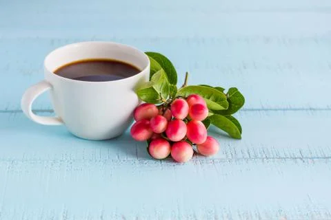 White coffee cup with black coffee and fruits on wooden table. Stock Photos