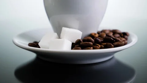 White coffee cup with coffee beans and refined sugar on a white background. Stock Footage 129363622