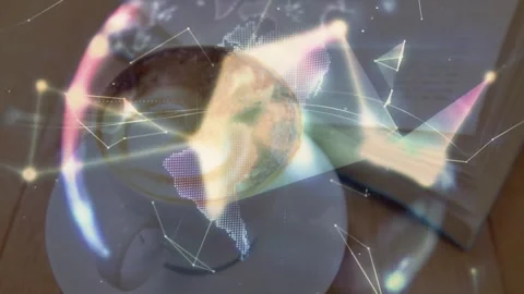 White coffee cup hovering on table beside open book and holographic globe Stock Footage 307445249