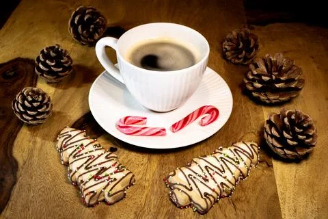 A white coffee cup with a red candy cane on top of it. Christmas coffee break Stock Photos