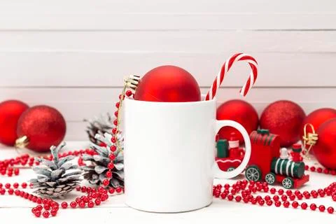 White coffee mug with candy cane and Christmas decorations on white backgroun Stock Photos