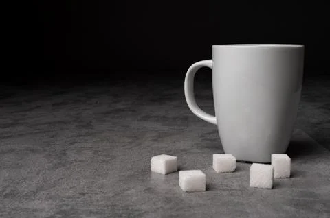 White Coffee Mug with Sugar Cubes on Grey Table Stock-Fotos