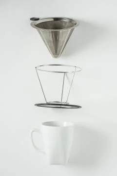 White coffee mug on white background. Metal pour over drip cone pulled apart. Stock Photos