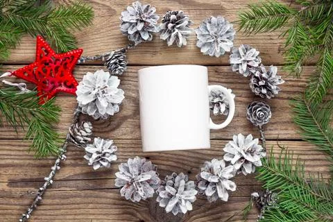 White coffee mug with white pine cones and fir branches. Space for text or de Stock Photos