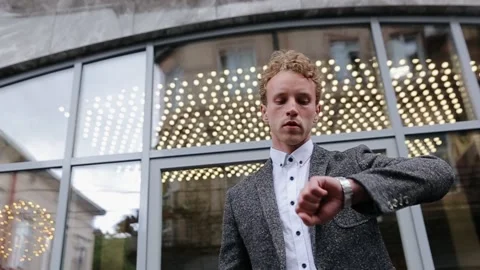 White collar man checks time on wristwatch at urban street. Businessman Stock Footage 134885417