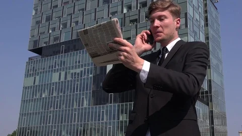 White collar worker reading financial newspaper businessman talking to client 4K Stock Footage