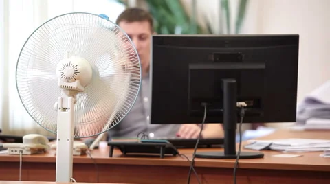 White collar worker unbuttoning his shirt under spinning cooling fan, office Stock Footage 48919294