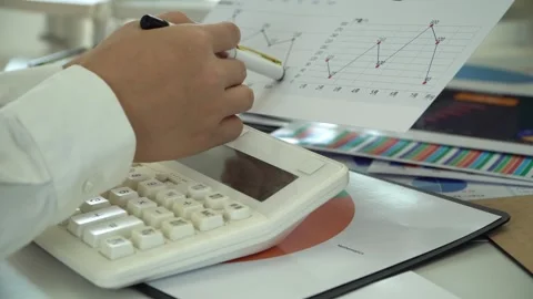 White collar worker uses calculator to calculate financial data Stock Footage 311985358