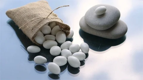 White colored dragee candies fall on glass background in slow motion Video stock 96711796
