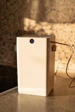 White compact humidifier operating on countertop Stock Photos