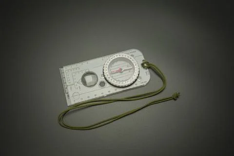 White compass rests on dark surface Stock Photos
