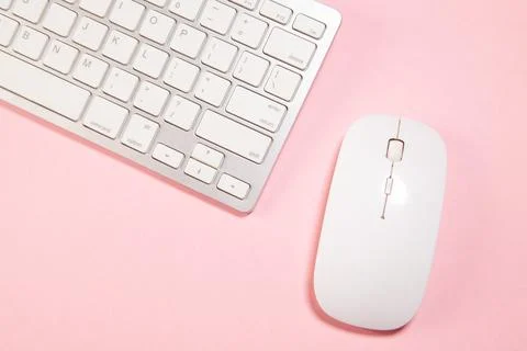 White computer keyboard and mouse on pink paper background Stock Photos