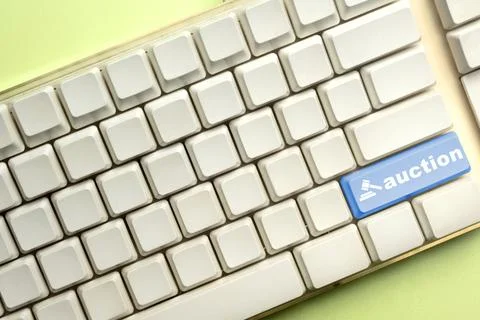A white computer keyboard featuring a prominent blue 'auction' key with a g.. Stock Photos