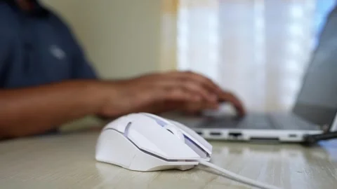 White Computer Mouse and Laptop in Office Setting, Close-up of a white comp.. Stock Footage 317736758