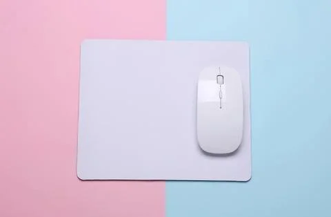 White computer mouse on mouse pad with pastel background Stock Photos