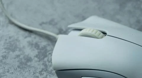 A white computer mouse is placed on a gray table with a concrete texture Stock Photos