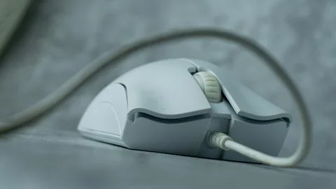 A white computer mouse is placed on a gray table with a concrete texture Stock Photos