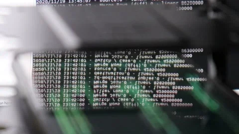 White computer software code moving on a black monitor reflect on glass. Abst Stock Footage 143674185