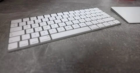 White computer wireless keyboard lying on a gray desk next to a trackpad Video stock 150208357