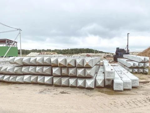 White concrete structures lie on wet ground. building material for the constr Stock Photos